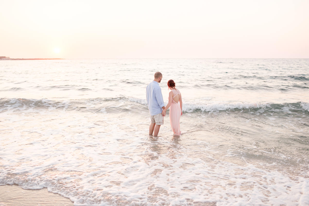 the couple gets in the sea during the last moments of the sunset