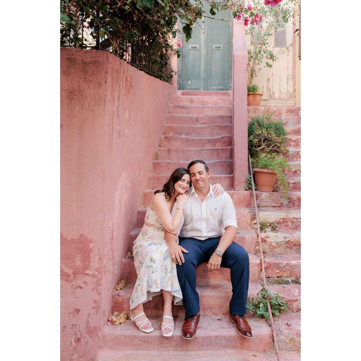 a couple is calm sitting together in love on the amazing pink stairs of Chania