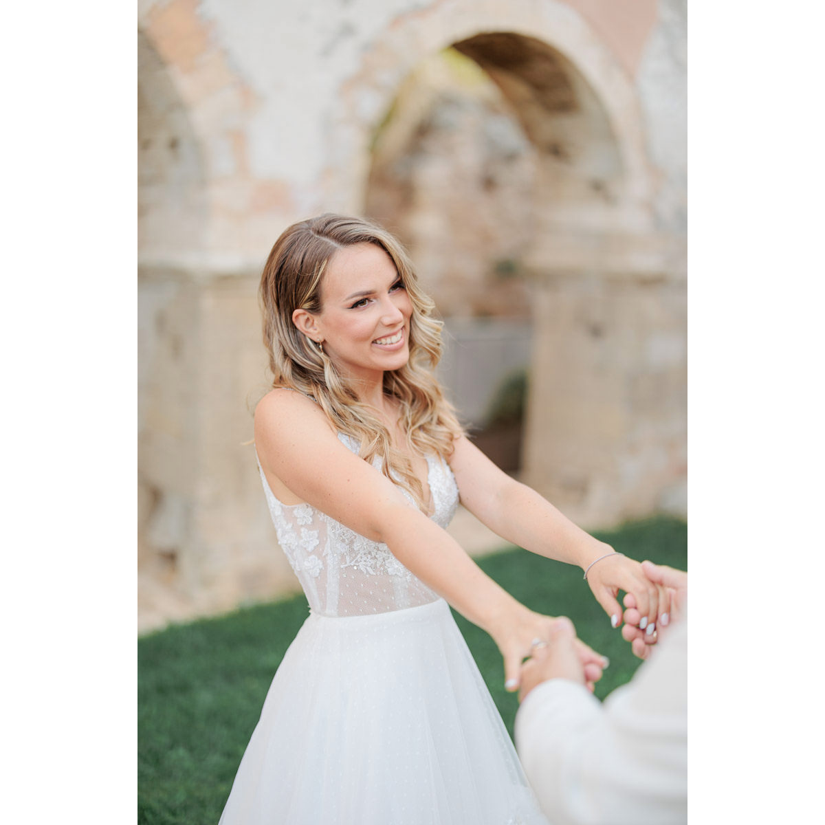 happy bride holding groom's hands