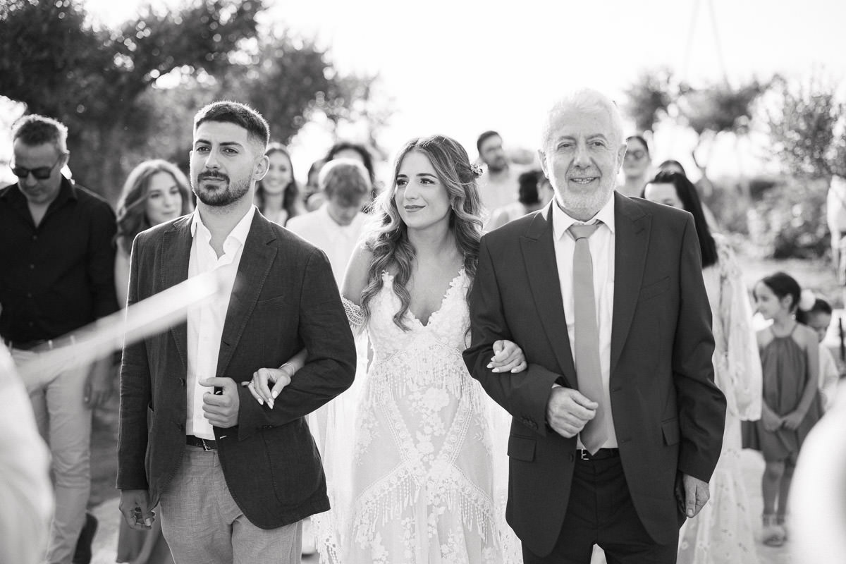 bride walking down the aisle with her father and her brother