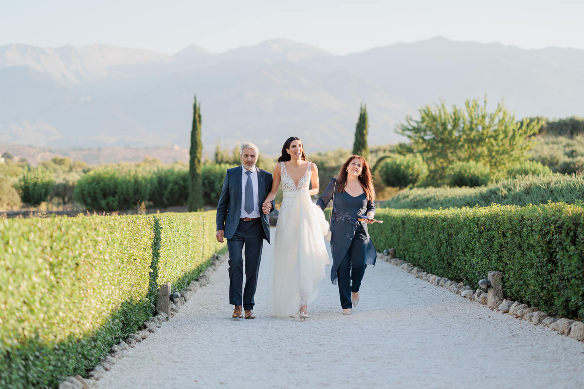 bride walking down the aisle with her parents