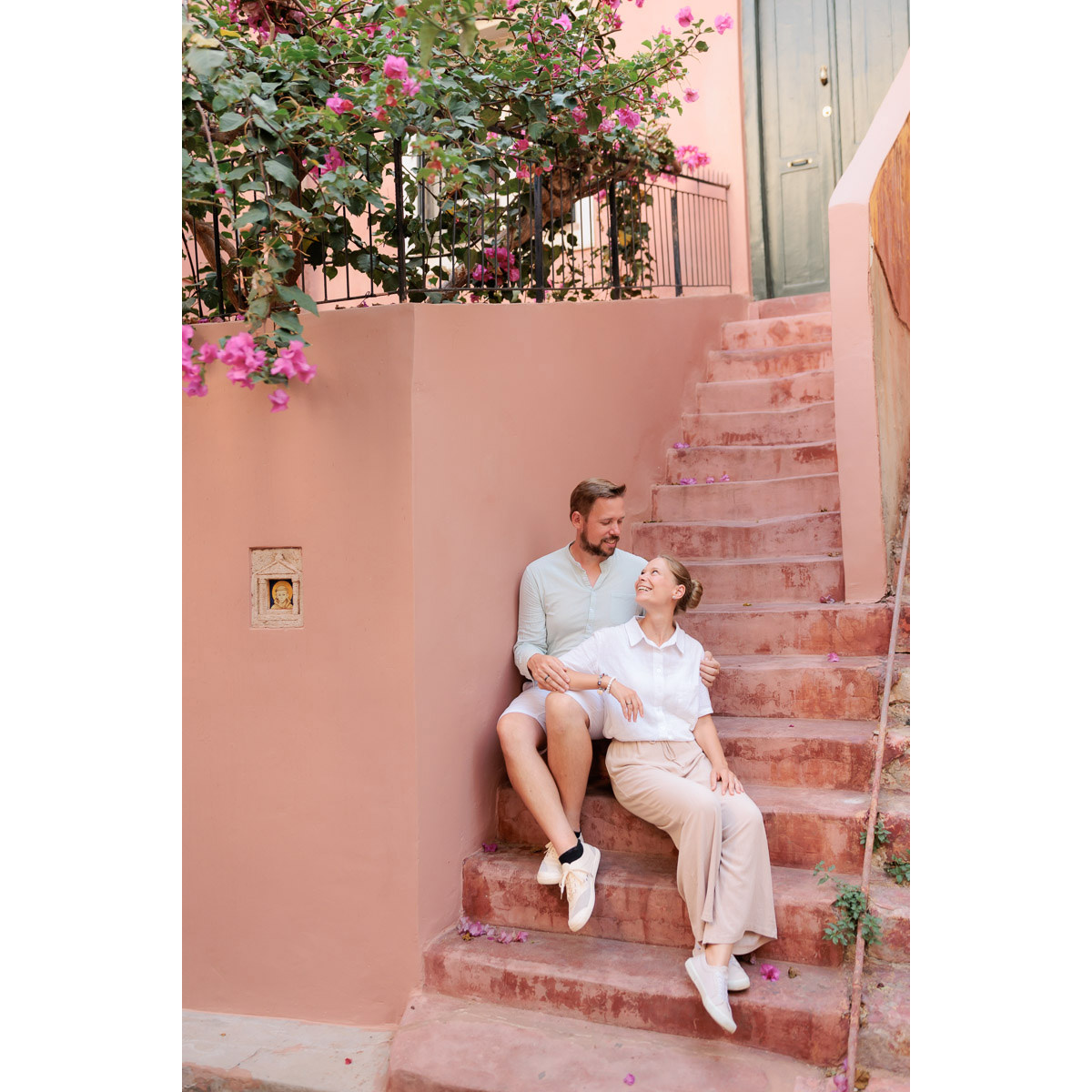 a couple sitting on the pink stairs